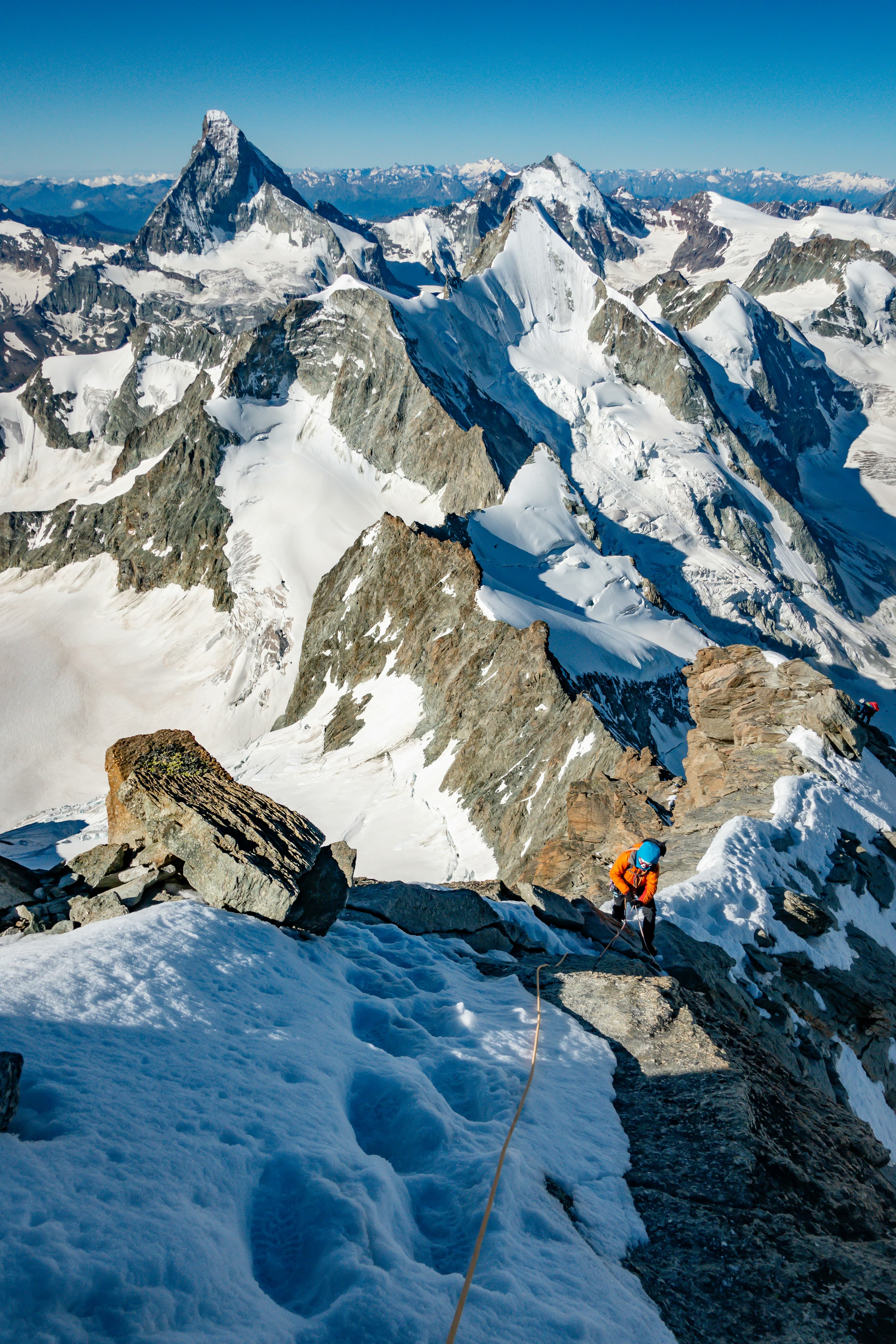 Climber ascending a high alpine ridge